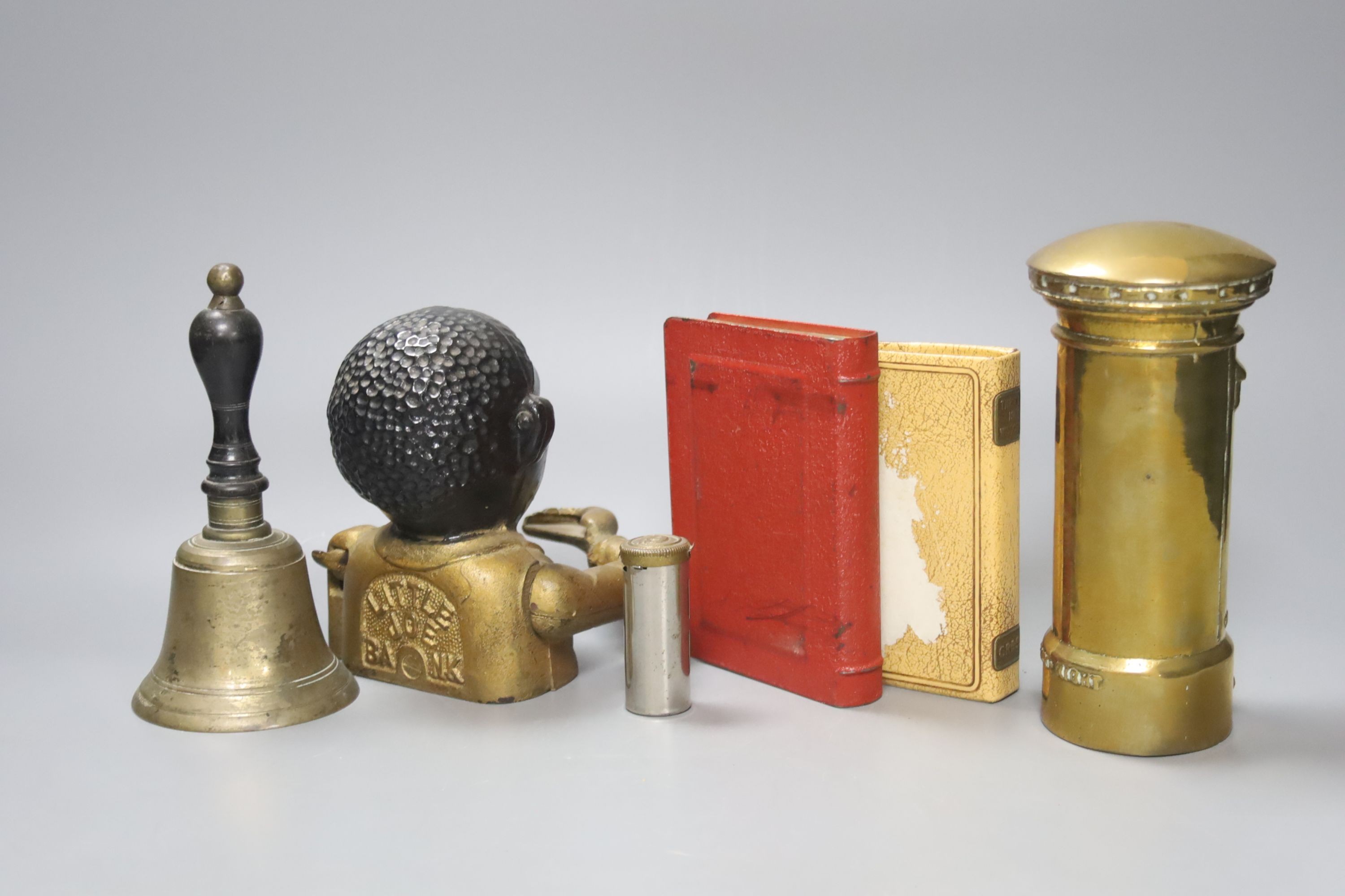 Little Joe cast iron money bank, three other money banks and a hand-bell 17cm